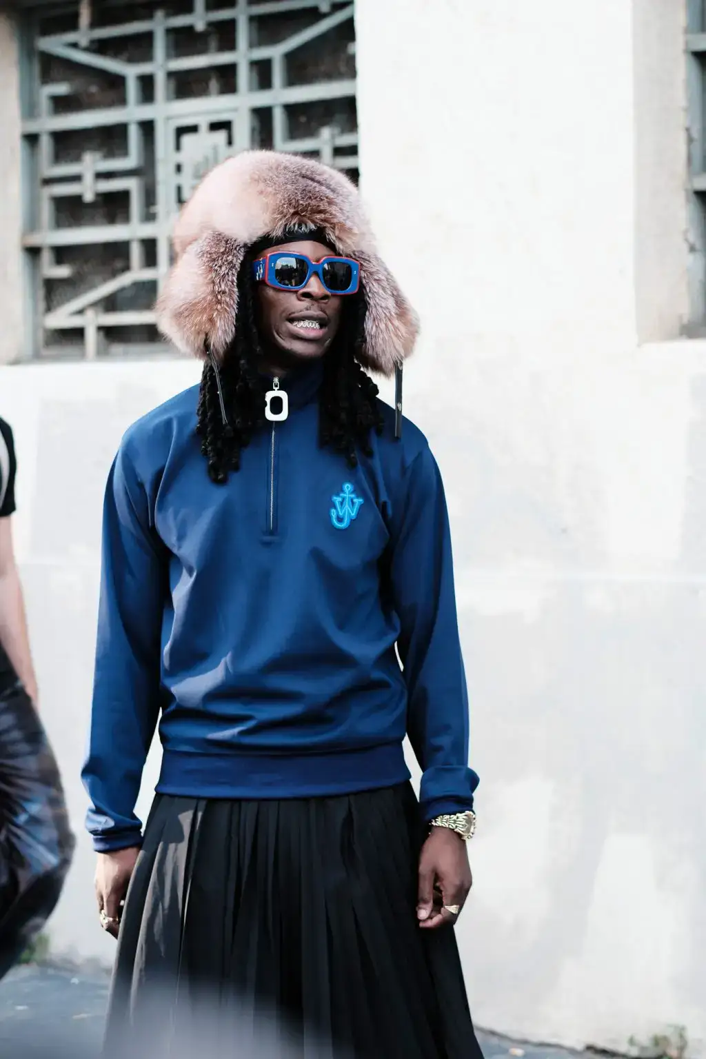 A guest arrives at the JW Anderson fashion show during the Milan Menswear Spring/Summer 2025 by Agnes Select
