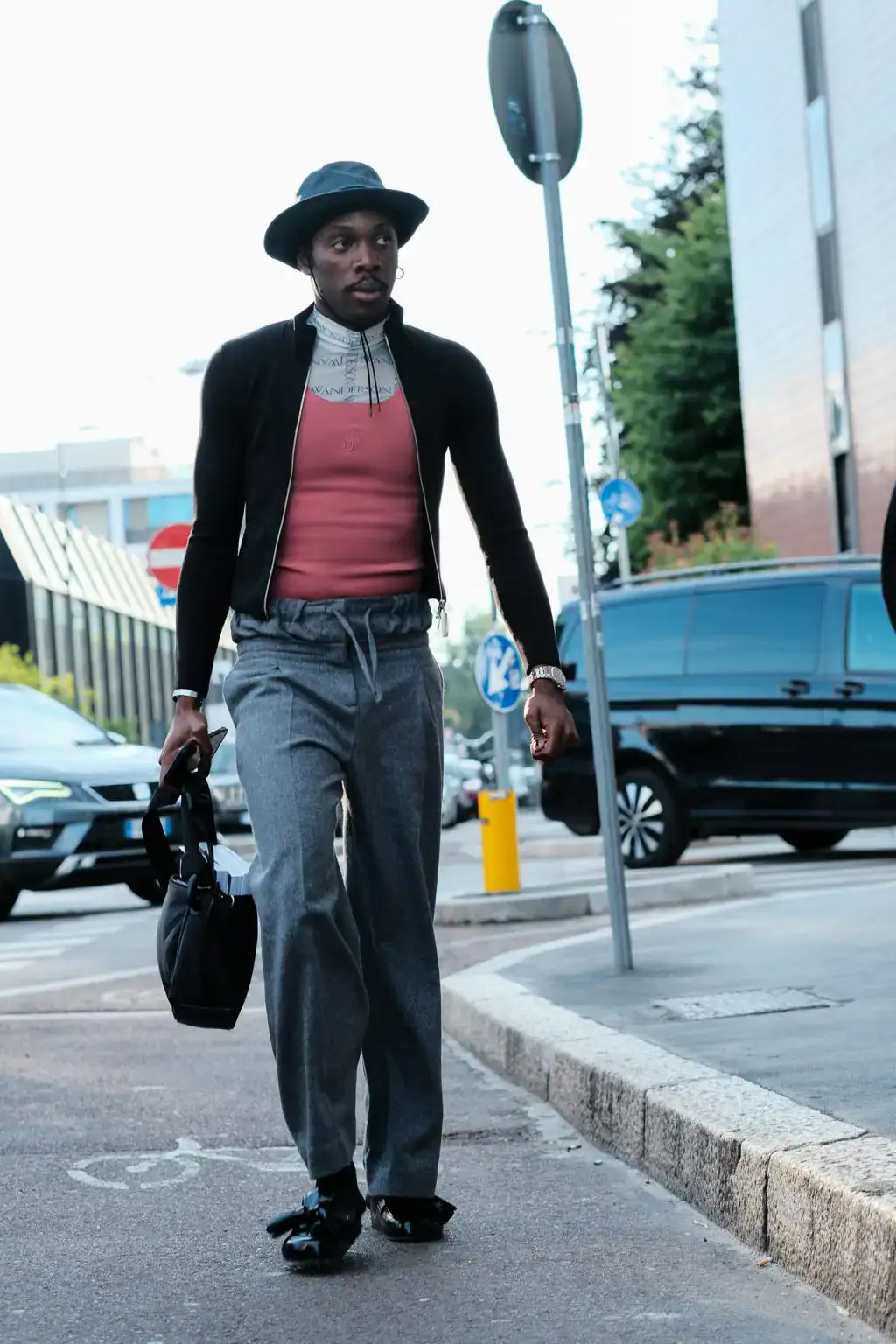 A guest arrives at the JW Anderson fashion show during the Milan Menswear Spring/Summer 2025 by Agnes Select