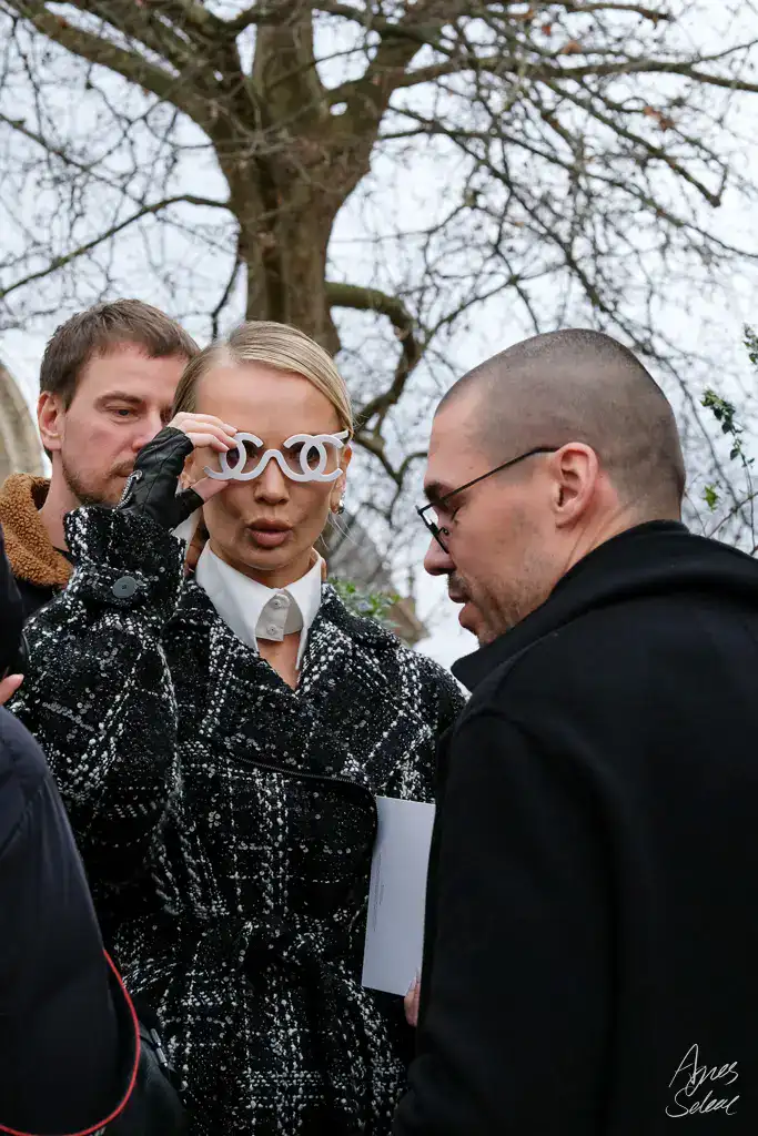Tatiana Korsakova at Paris Haute Couture Week in a black-and-white tweed coat, white shirt, and Chanel double-C sunglasses. @tatianakorsakova
